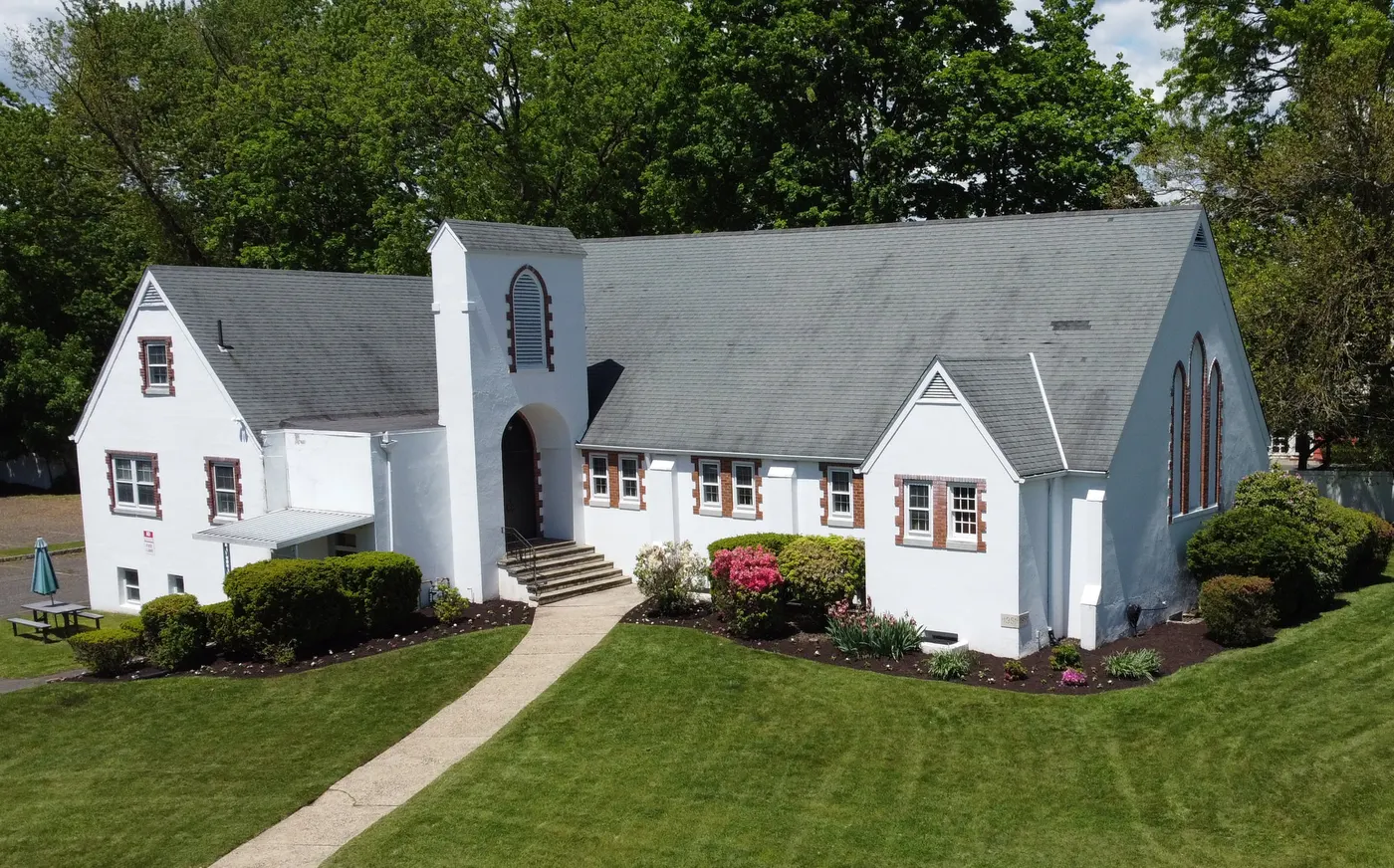 The front of Englewood Baptist Church with flowering shrubs